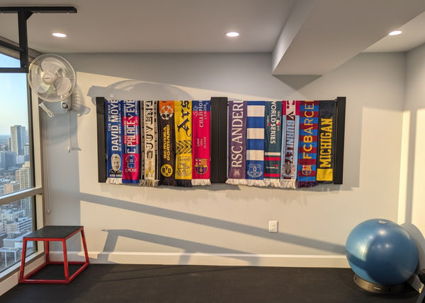 Soccer scarf collection displayed above home gym equipment