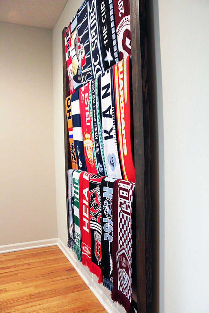 Bernabeu Soccer Scarf Display Rack: Side view of wooden rack with neatly arranged scarves.